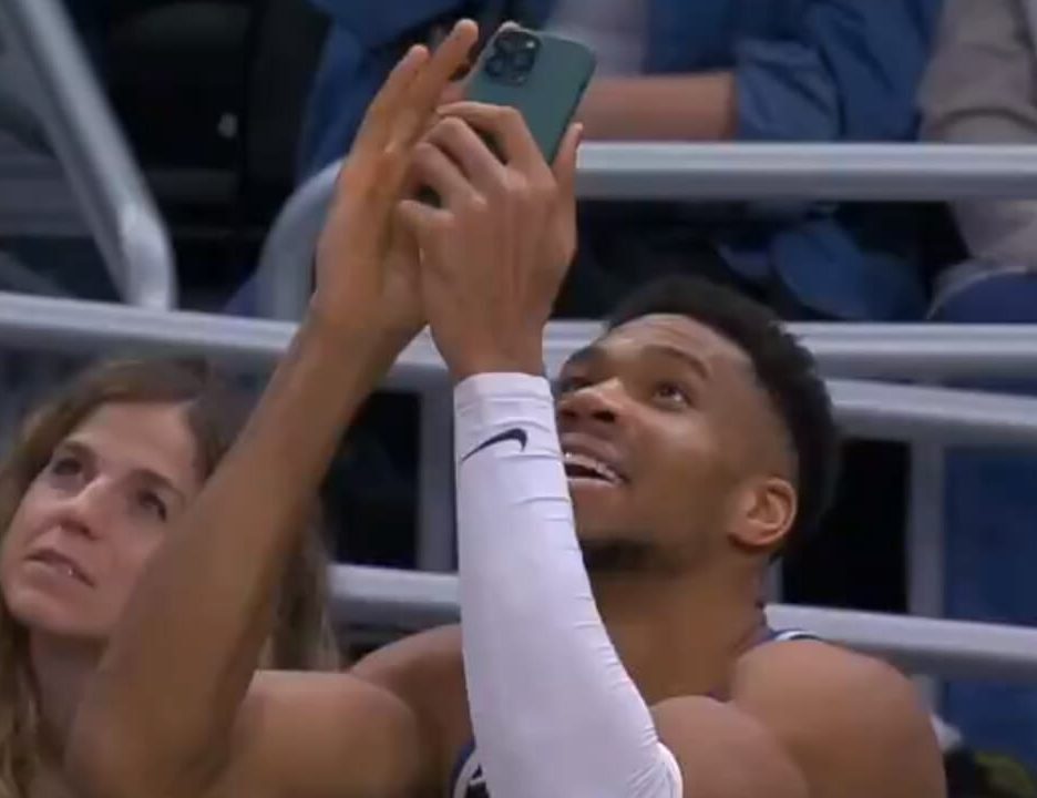 Giannis Antetokounmpo Scans QR Code With Mobile Phone To Get Free Chicken Wings From Wingstop